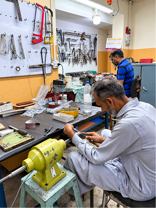 Craftsman polishing an instrument on a buffing machine