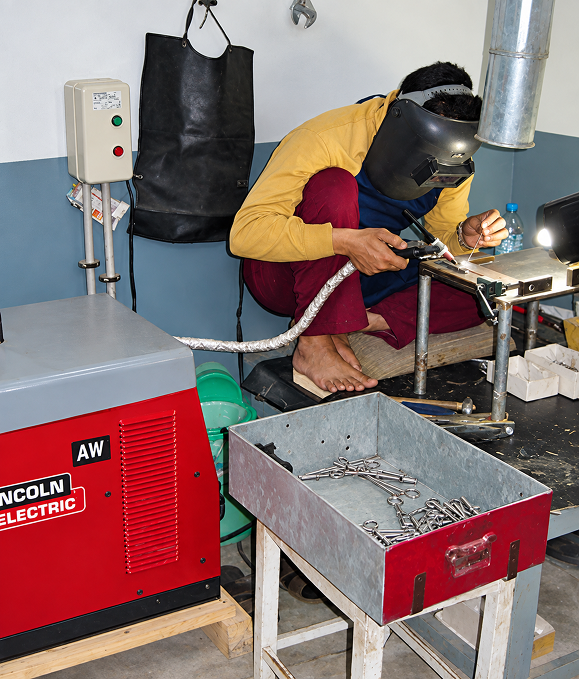 Welder joining surgical instrument parts at a welding station